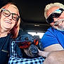 black_dog, car_interior, casual_clothing, checkered_pattern, couple, dog, fun, hand, happy, indoors, man, pet_carrier, portrait, reflection, road_trip, smiling, summer, sunglasses, travel, woman