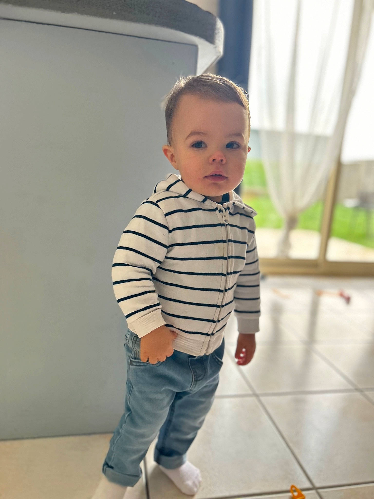 Milo a rejoint le concours — aidez-le/la à gagner de superbes lots ! baby, baby_toddler_clothing, child, cleanliness, composite_material, denim, fashion_design, floor, flooring, fun, happy, hardwood, knee, leg, pattern, person, room, sleeve, t_shirt, toddler