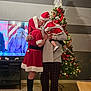 Novalee joined the competition — help win amazing prizes! christmas, holiday, family, child, woman, person, santa_claus_costume, tree, decorations, lights, kiss, indoor, floor, television, furniture, boots, pajamas, festive, celebration, love