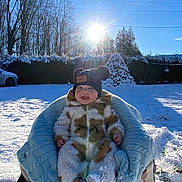 Milyo a rejoint le concours — aidez-le/la à gagner de superbes lots ! baby, child, snow, winter, sunlight, blue_sky, hat, snowsuit, blanket, outdoor, smiling, happy, chair, trees, car, sunflare, cold, nature, daylight, fuzzy_clothing