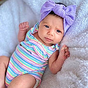 Demi is registered to the contest to win money with this photo: baby, bow, comfortable, curious_expression, cute, face, fist, fluffy_blanket, headband, indoors, infant, lying_down, newborn, onesie, person, portrait, skin, soft_texture, striped_clothing, white_blanket