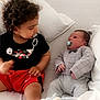 baby, toddler, child, pacifier, bed, pillow, blanket, clothing, curly_hair, indoor, cute, infant, sibling, cozy, relaxed, casual, white_bed, soft_lighting, cute_outfit, family