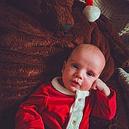 James joined the competition — help win amazing prizes! baby, black_belt, blanket, buttoned_shirt, candid, child, cozy, cute, festive, holiday_clothing, holiday_theme, indoor, infant, plush_teddy_bear, portrait, red_outfit, resting, santa_hat, soft_texture, warm_lighting