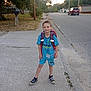 backpack, blue_clothing, boy, car, casual, child, concrete, daylight, house, outdoor, person, pose, sidewalk, sneakers, street, suburban, summer, tree, urban, young
