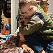Christopher is registered to the contest to win money with this photo: animal, blanket, boy, candid, casual_clothing, child, comfort, cozy, dog, face, friendship, furniture, happy, home, hug, indoor, paw, pet, smile, sweater