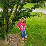 Isabella is registered to the contest to win money with this photo: child, girl, pink_shirt, jeans, tree, grass, outdoor, smiling, nature, leaves, sidewalk, shoes, casual_clothing, playful, happy, greenery, daylight, young, portrait, cute