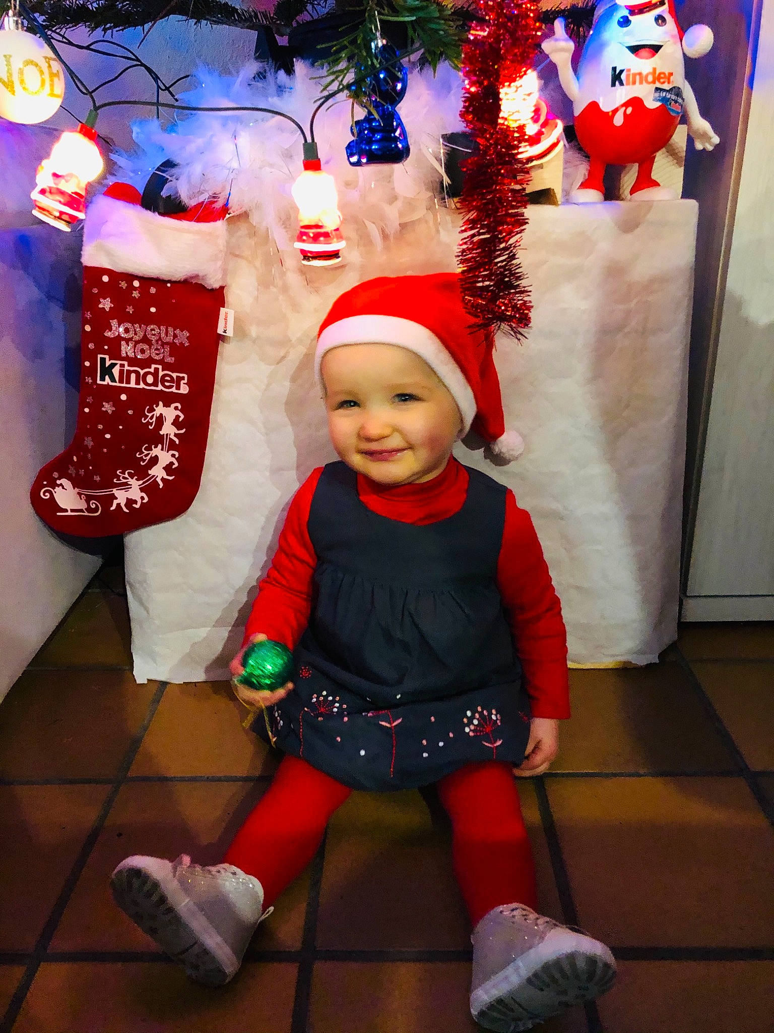Ophélie a rejoint le concours — aidez-le/la à gagner de superbes lots ! baby, baby_toddler_clothing, child, christmas, christmas_decoration, christmas_eve, christmas_lights, costume, costume_accessory, costume_hat, event, fictional_character, headwear, holiday, interior_design, joy, party_supply, person, red, sock
