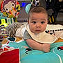 baby, infant, play_mat, toy, rattle, bib, colorful, indoor, child, face, curious, crawling, floor, striped_pants, soft_toys, head, young_child, clothing, cute, expression