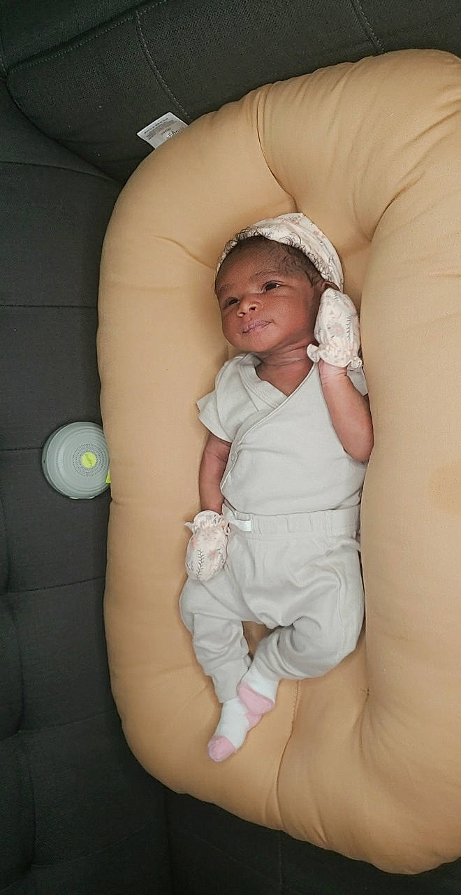 Kisha is registered to the contest to win money with this photo: arm, baby, baby_toddler_clothing, cheek, comfort, eye, finger, hand, head, human_body, knee, leg, mouth, neck, nose, person, skin, sleeve, thigh, thumb