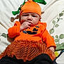 Nunliah is registered to the contest to win money with this photo: baby, bare_feet, bed, black_pants, blanket, child, costume, cute, fall_theme, green_leaves, hand_on_mouth, holiday, indoors, infant, orange_clothing, pillow, portrait, pumpkin_hat, sitting, soft_lighting