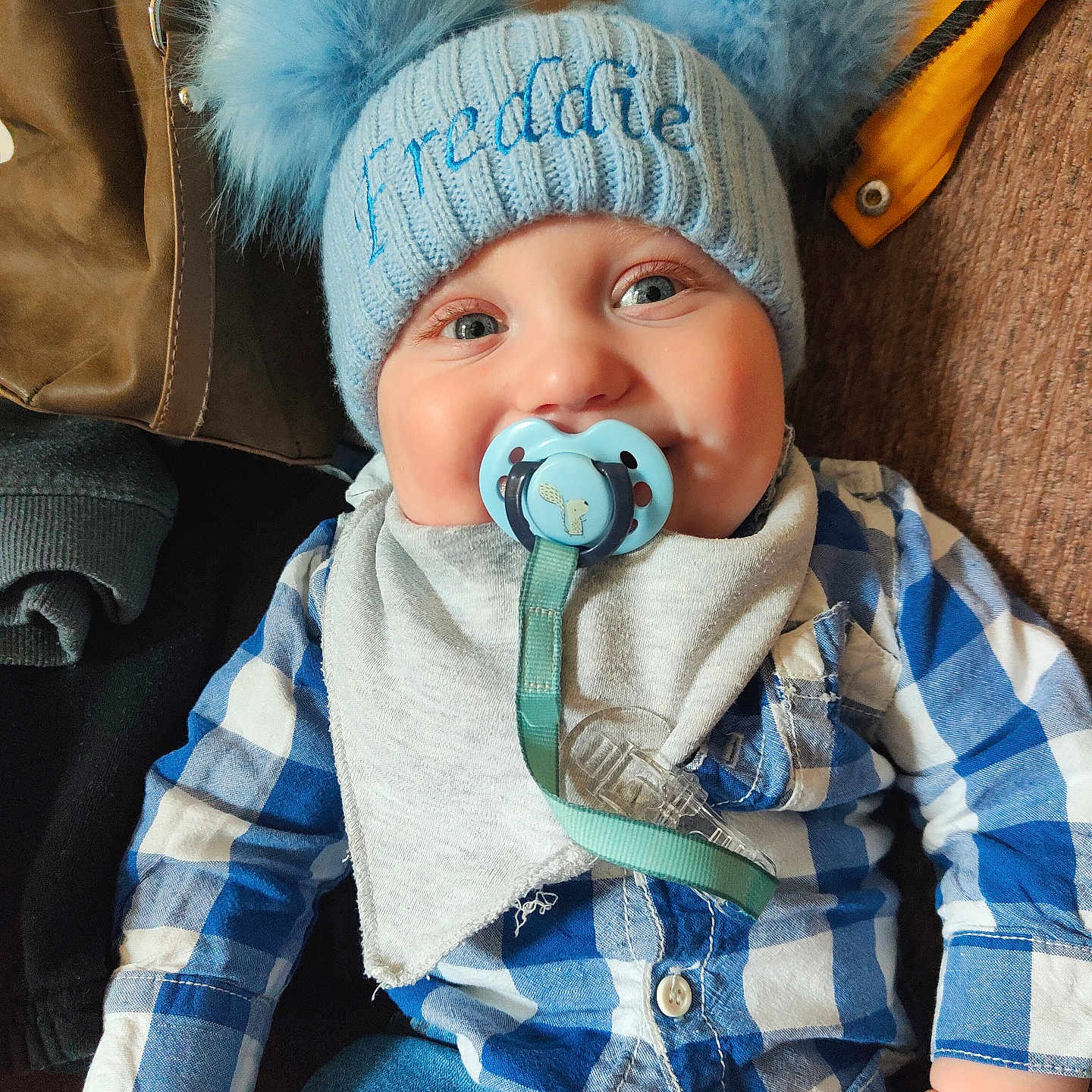Freddie is registered to the contest to win money with this photo: baby, beanie, bodypart, bonnet, cap, clothing, coat, couch, face, finger, furniture, hand, hat, head, jacket, jeans, pants, person, photography, portrait