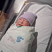 Elizabeth joined the competition — help win amazing prizes! newborn, baby, infant, hospital, blanket, hat, bassinet, swaddled, sleeping, face, person, bed, medical, newborn_baby, cute, indoors, child, healthcare, resting, wrapped