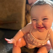 Annalise is registered to the contest to win money with this photo: baby, child, smile, face, indoor, pink_outfit, sitting, cheeky, happy, light, carpet, hand, cute, infant, expression, person, young_child, skin, hair, background