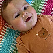 Mathéo participe au concours pour gagner de l'argent avec cette photo : animal_print, baby, blanket, child, clothing, colorful, cute, eyes, face, happy, head, infant, laying_down, portrait, skin, smile, striped, tiger, tshirt, young_child