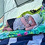 baby, baby_boy, blanket, child, clothing, colorful, cute, hat, infant, lying_down, outdoor, pacifier, relaxing, resting, shade, soft_light, summer, sun_hat, tent, towel