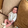 baby, blanket, child, clothing, comfort, couch, cozy, cute, home, indoor, infant, pacifier, person, pillow, pink_pants, relaxing, seated, socks, soft_furnishings, white_cardigan