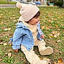 toddler, child, outdoor, autumn, grass, fallen_leaves, beanie, denim_jacket, pacifier, cozy_clothing, park, curious_expression, fall_foliage, casual_wear, sitting, cute, warm_clothes, nature, young_child, daytime