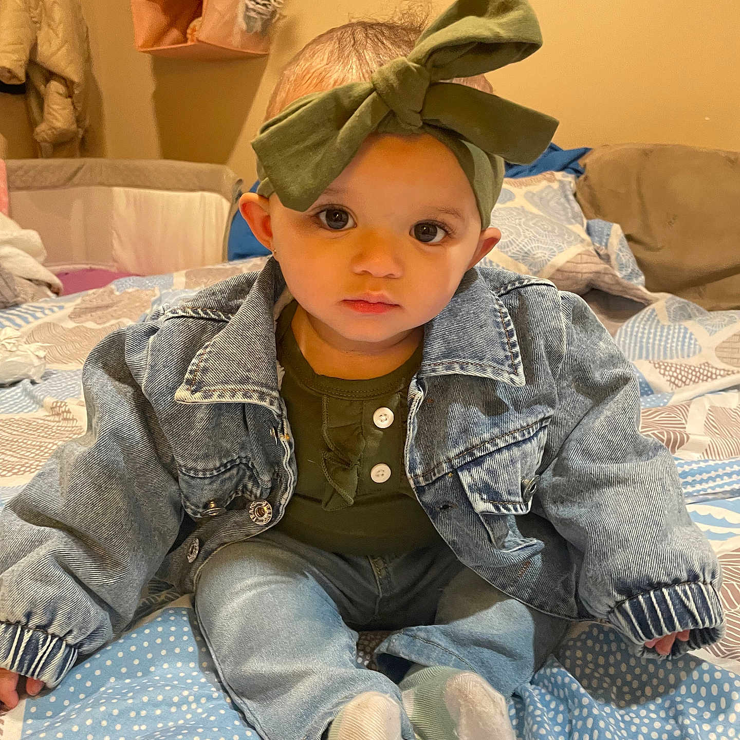 Serenity is registered to the contest to win money with this photo: baby, bed, bedroom, clothing, coat, couch, face, furniture, hat, head, hosiery, indoors, jacket, jeans, pants, person, photography, portrait, room, sitting