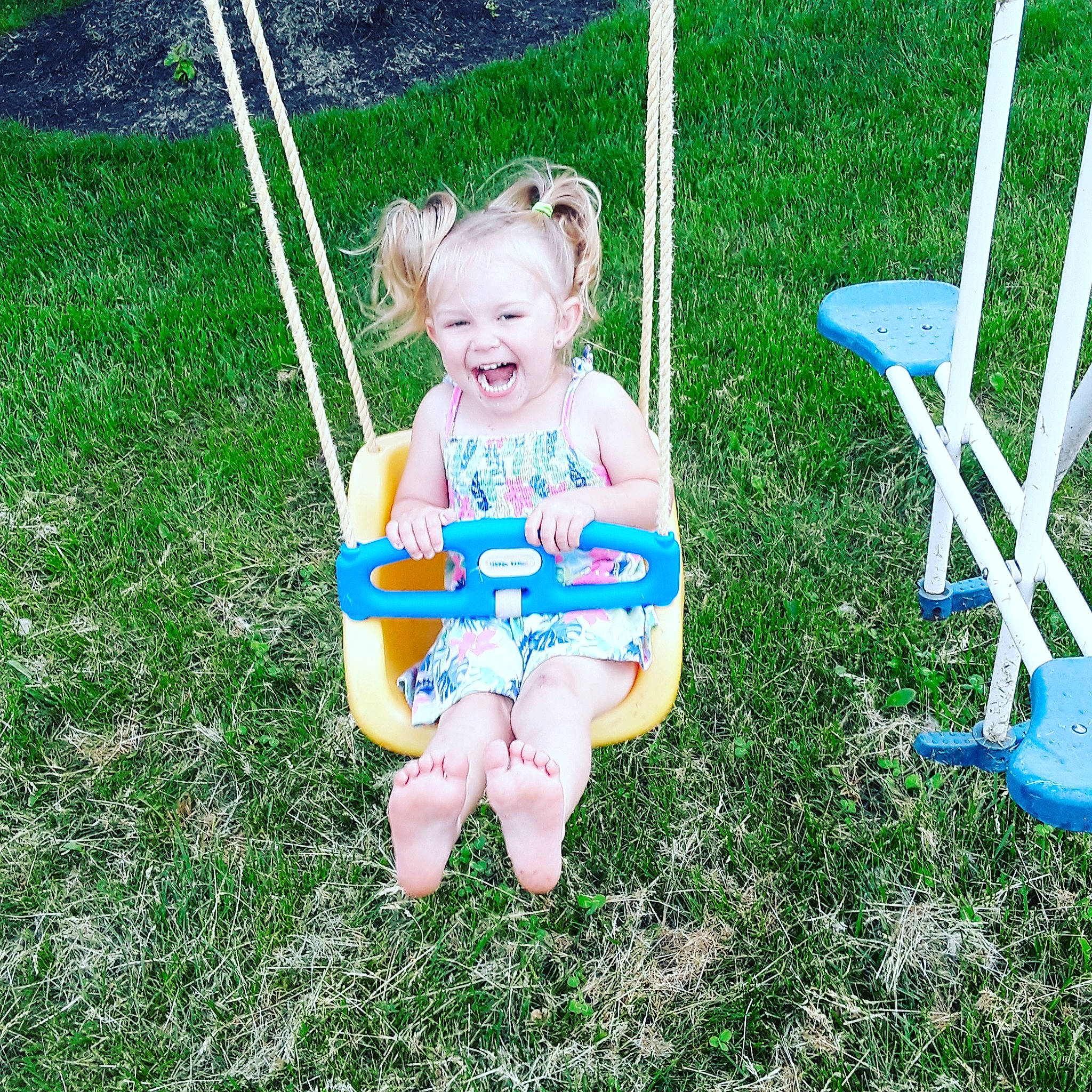 Minnie is registered to the contest to win money with this photo: baby, child, fun, grass, happy, joy, lawn, outdoor_play_equipment, person, plant, play, playground, public_space, sitting, smile, summer, swing, toddler, vacation