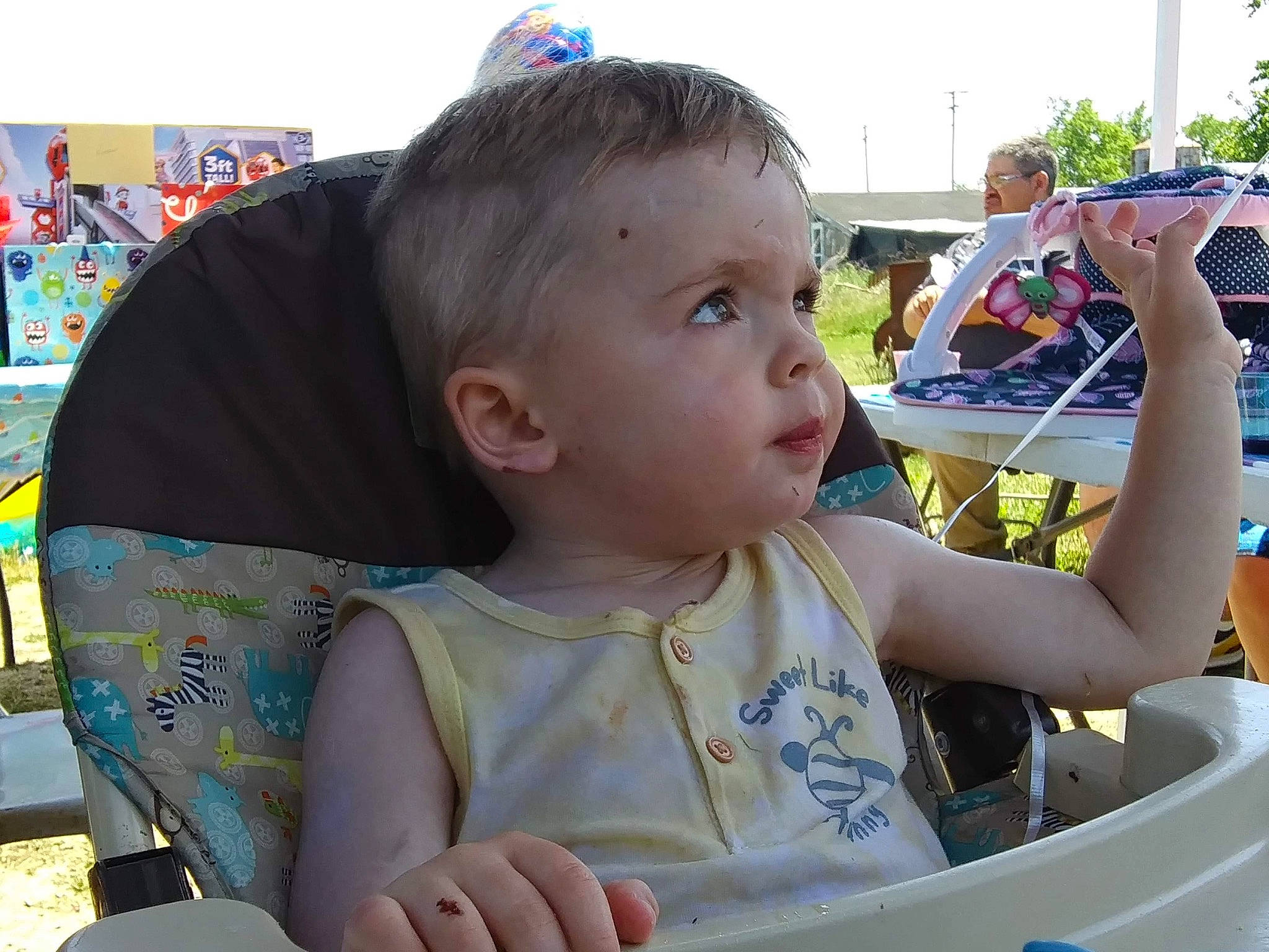 Roman is registered to the contest to win money with this photo: baby, child, event, eyewear, fun, grass, happy, leisure, motor_vehicle, person, play, product, recreation, sitting, skin, sky, summer, t_shirt, toddler, tree