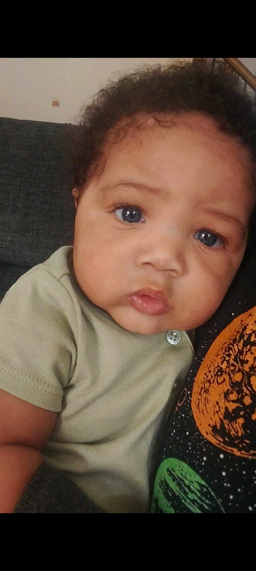 Mikouri Hill is registered to the contest to win money with this photo: baby, button, casual, child, close_up, clothing, couch, curly_hair, cute, expression, eyelashes, face, family, indoor, person, portrait, skin, soft_light, toddler, young_child