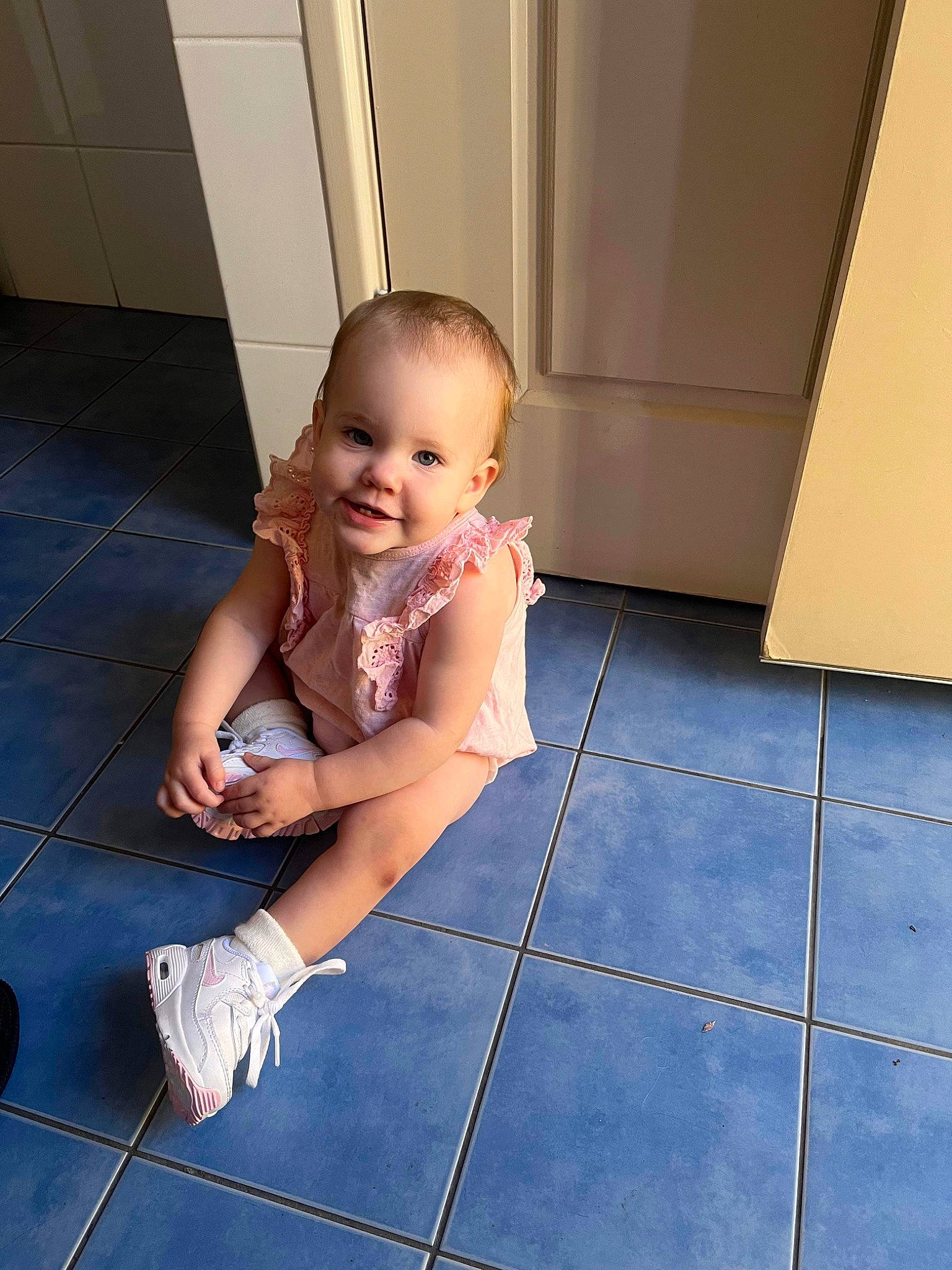 Ayla is registered to the contest to win money with this photo: baby, baby_toddler_clothing, barefoot, child, electric_blue, floor, flooring, foot, hardwood, human_leg, joy, knee, leg, leisure, person, shoulder, sitting, skin, smile, thigh