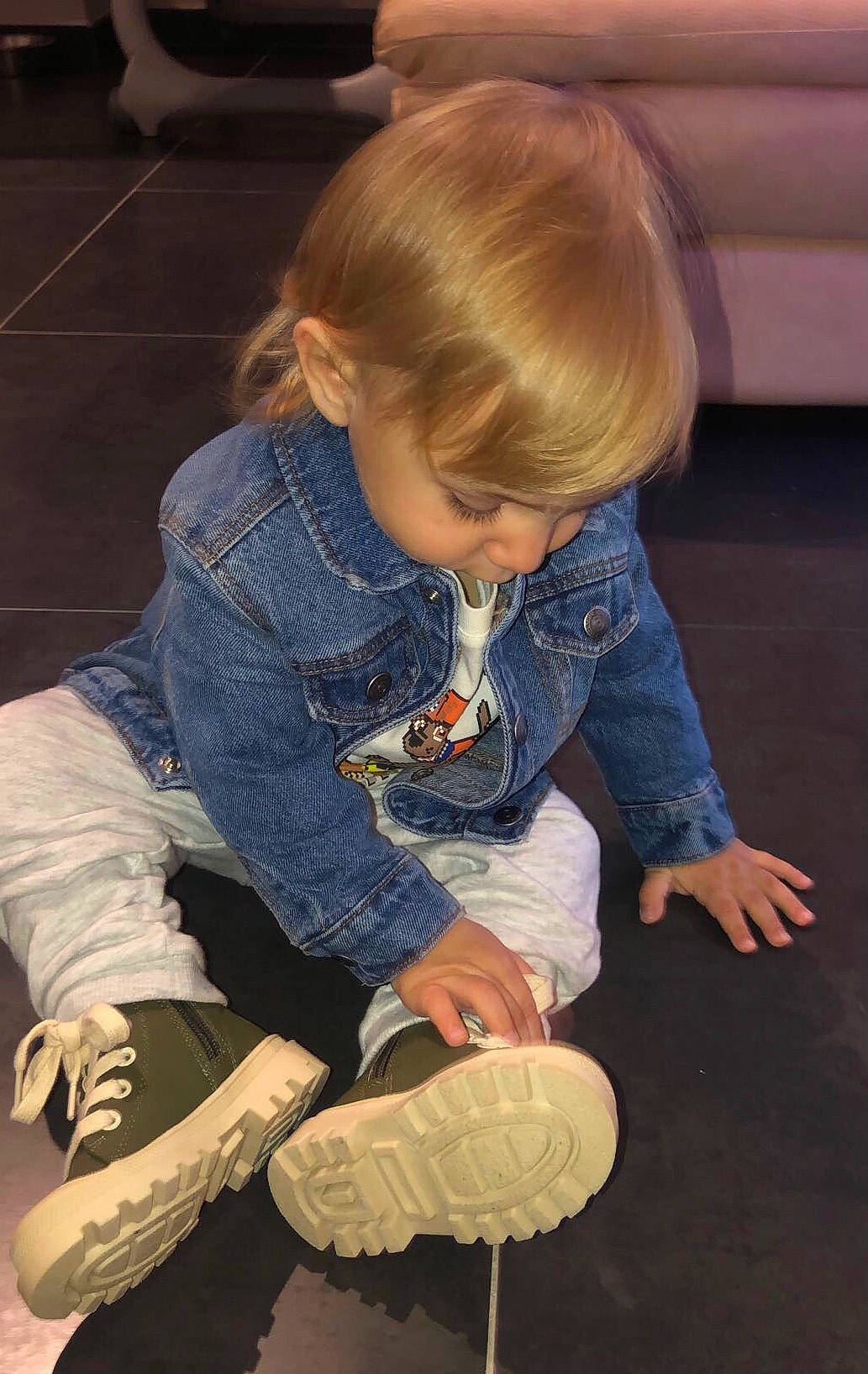 Malone a rejoint le concours — aidez-le/la à gagner de superbes lots ! baby_toddler_clothing, ball, child, denim, electric_blue, floor, flooring, fun, hardwood, hat, human_leg, joint, knee, leg, person, shoe, sitting, sneakers, sock, toddler