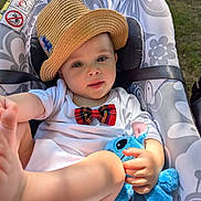 Castiel participe au concours pour gagner de l'argent avec cette photo : baby, child, hat, bow_tie, plush_toy, blue_toy, baby_seat, outdoor, grass, foot, hand, clothing, cute, playful, smiling, infant, face, portrait, sunlight, relaxing