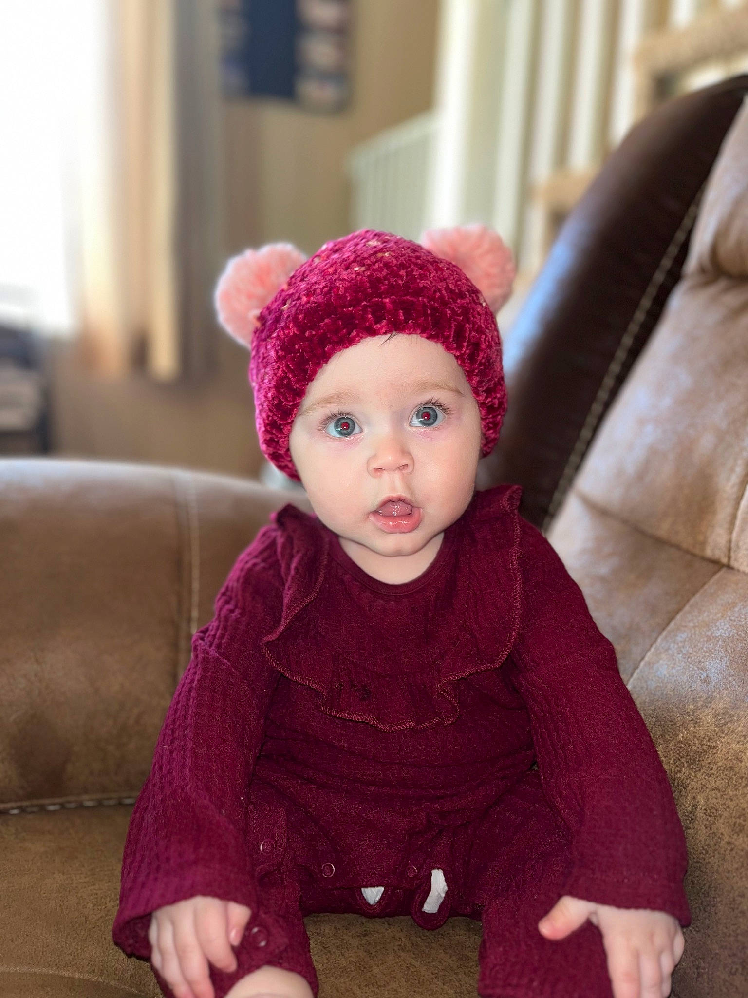 Ayla joined the competition — help win amazing prizes! baby, baby_toddler_clothing, cap, child, comfort, costume_hat, couch, face, flooring, headwear, knit_cap, magenta, outerwear, pattern, person, pink, purple, sleeve, surprise, textile