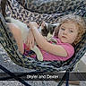 child, cat, hammock_chair, outdoor, curly_hair, pink_shirt, pet, hugging, relaxing, concrete_floor, wooden_fence, grill, patterned_fabric, animal, person, comfort, daylight, young_child, resting, casual