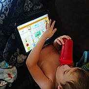 Hunter joined the competition — help win amazing prizes! child, tablet, red_cup, blanket, couch, indoors, relaxing, device, screen, learning, hand, young_child, casual, comfort, technology, drinking, skin, resting, home, portrait