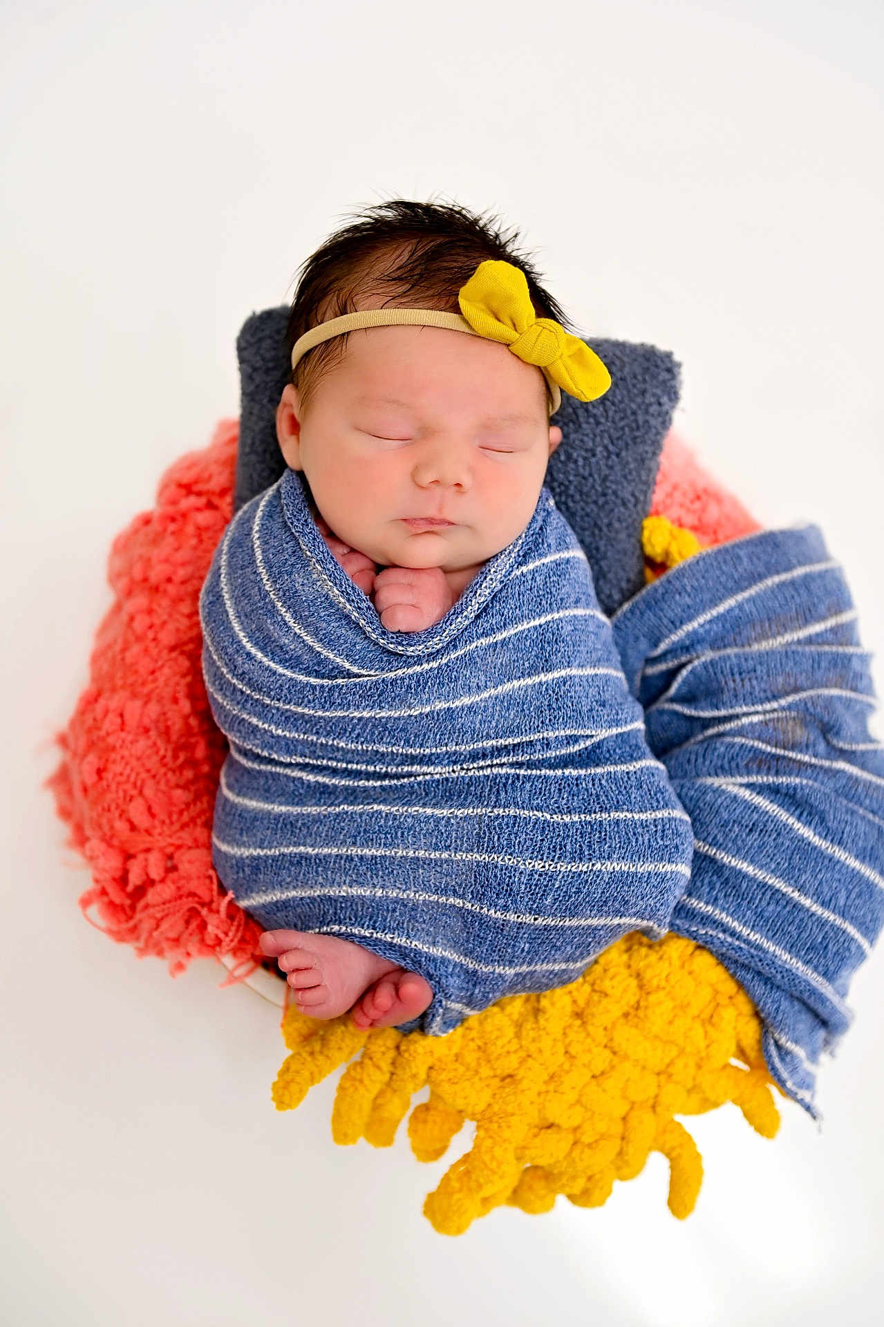Koda is registered to the contest to win money with this photo: newborn, baby, sleeping, wrapped, blanket, headband, yellow_bow, blue_stripes, pink_blanket, yellow_blanket, cozy, soft, cute, portrait, infant, peaceful, tiny_feet, hands, studio, white_background