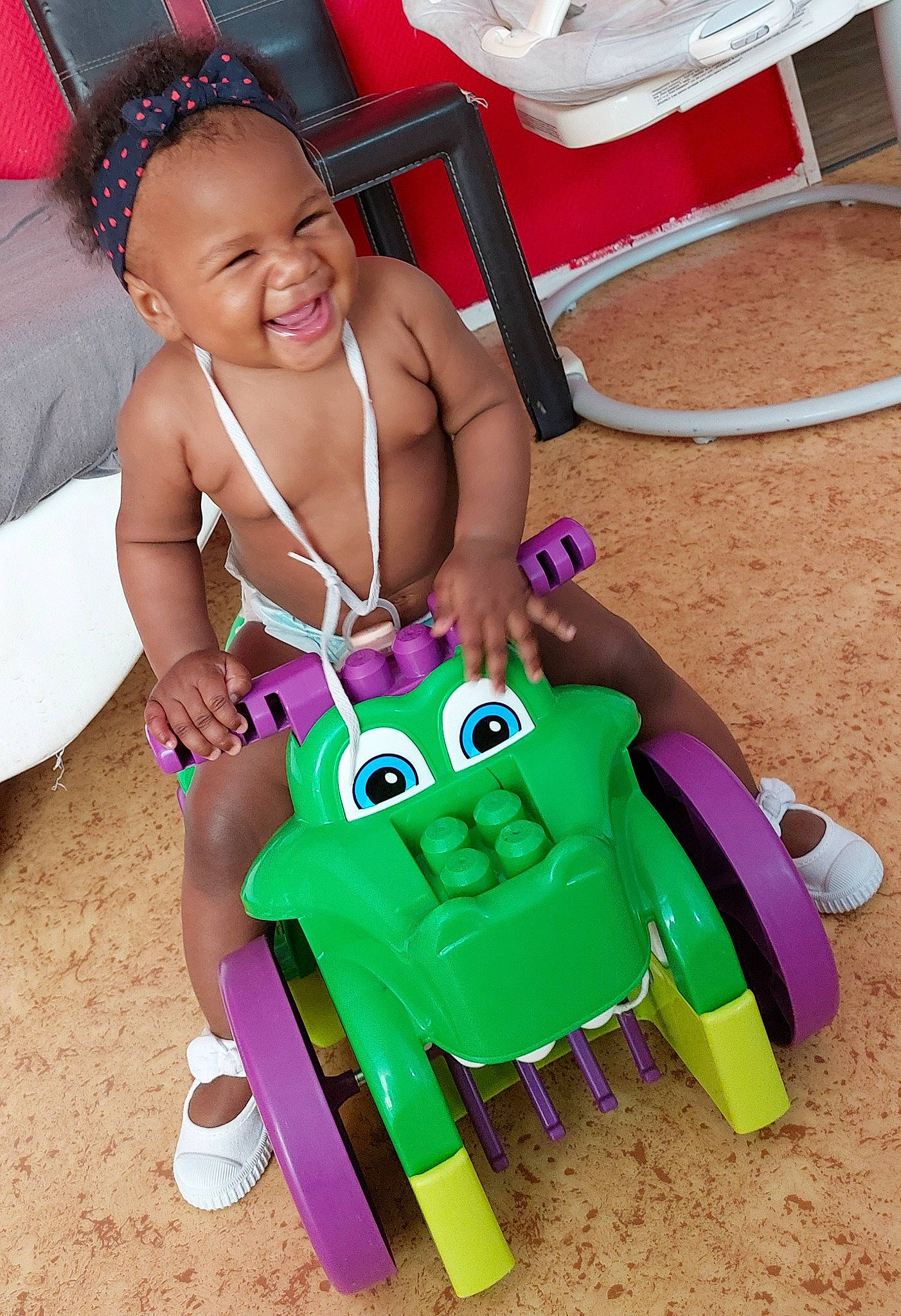 Kaylah a rejoint le concours — aidez-le/la à gagner de superbes lots ! baby_playing_with_toys, baby_products, child, event, fun, happy, joy, leisure, magenta, party_supply, person, pink, play, recreation, riding_toy, shoe, sitting, smile, tire, toddler