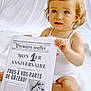 Juliette participe au concours pour gagner de l'argent avec cette photo : toddler, child, baby, blue_eyes, white_background, newspaper, first_birthday, sign, sitting, portrait, smiling, cute, happy, clothing, indoor, holding, celebration, hair_tie, skin, light