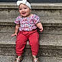 toddler, child, smiling, sitting, steps, concrete, headband, bow, floral_top, red_pants, gold_sandals, outdoor, happy, cute, portrait, person, fashion, accessories, jewelry, casual