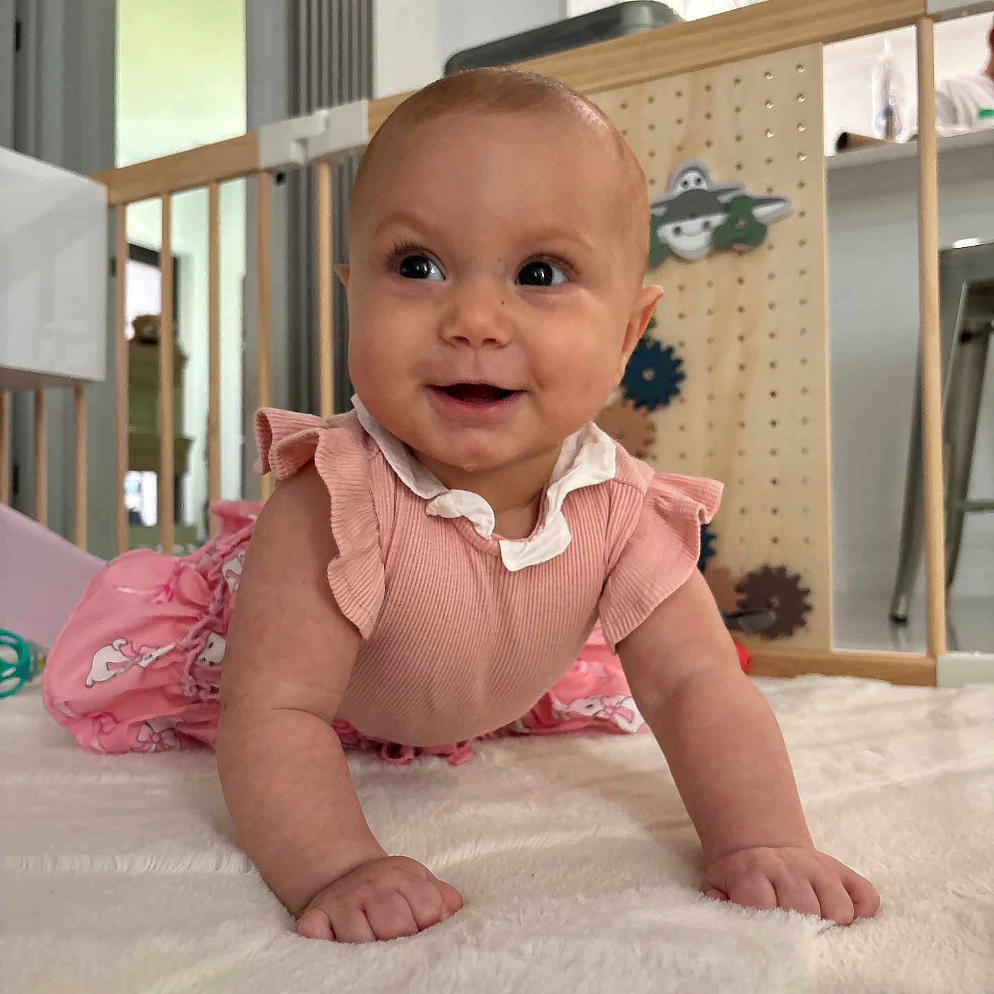 Marielaura is registered to the contest to win money with this photo: baby, infant, crawling, pink_clothing, smiling, happy, indoor, soft_surface, baby_gate, toy, child, person, cute, home, floor, playful, young_child, bright_eyes, closeup, portrait