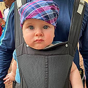 Jasper joined the competition — help win amazing prizes! adult, baby, baby_carrier, background, blue_shirt, brick_wall, child, closeup, clothing, expression, eyes, face, hand, headwear, outdoor, people, person, plaid_hat, portrait, strap