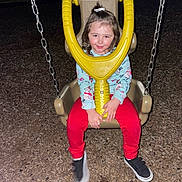 Olivia is registered to the contest to win money with this photo: child, swing, playground, night, wood_chips, chains, smile, red_pants, blue_shirt, shoes, play, outdoor, fun, happy, seat, metal, toy, person, clothing, flash_photo