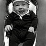 Ayan a rejoint le concours — aidez-le/la à gagner de superbes lots ! baby, baby_bouncer, black_and_white, bouncer, child, clothing, cute, expression, face, footwear, happy, hat, indoor, infant, joyful, onesie, person, seat, sitting, smiling