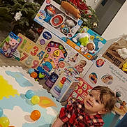 Valentina participe au concours pour gagner de l'argent avec cette photo : baby, child, christmas_tree, colorful_balls, cute, decorations, festive, floor, gift_boxes, happy, holiday, home, indoor, person, play_mat, plush_toy, red_shirt, smiling, toddler, toys