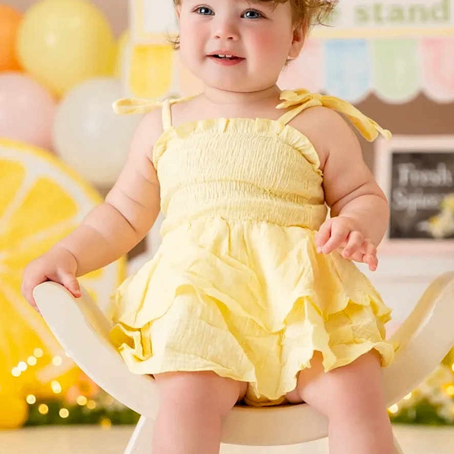 Lily is registered to the contest to win money with this photo: toddler, child, yellow_dress, headband, chair, balloons, smiling, happy, indoor, portrait, baby, cute, celebration, decorations, feet, person, face, event, fun, bright