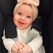 Romy a rejoint le concours — aidez-le/la à gagner de superbes lots ! baby, blue_eyes, car_seat, child, clothing, cute, hands, happy, headwear, indoor, infant, person, pink_bow, pink_pants, portrait, safety_harness, seatbelt, smiling, white_shirt, young