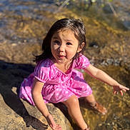 Zara is registered to the contest to win money with this photo: child, girl, pink_dress, water, rocks, outdoor, nature, boots, sunlight, shadow, playful, curious, sitting, summer, daylight, happy, portrait, young, water_edge, exploration