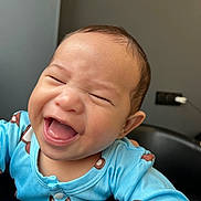 Heimana participe au concours pour gagner de l'argent avec cette photo : baby, laughing, blue_clothing, infant, happy, face, portrait, indoor, onesie, child, cute, smile, human, person, skin, head, young, expression, joy, closeup