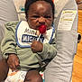 Michael joined the competition — help win amazing prizes! baby, baby_seat, bib, child, clothing, cute, diaper, face, footwear, green_sweater, hand, holding, indoor, infant, lollipop, monkey_design, pattern, serious_expression, sitting, wooden_floor