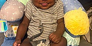 Michael is registered to the contest to win money with this photo: baby, bed, blanket, child, comfort, cozy, cute, face, happy, indoors, infant, pacifier, person, plush_pillow, sitting, smiling, sock, soft_toys, striped_clothing, tongue_out