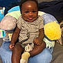 baby, bed, blanket, child, comfort, cozy, cute, face, happy, indoors, infant, pacifier, person, plush_pillow, sitting, smiling, sock, soft_toys, striped_clothing, tongue_out