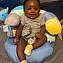 Michael is registered to the contest to win money with this photo: baby, bedroom, child, comfort, cute, dinosaur_toy, face, happy, indoor, infant, pacifier, person, plush_seat, portrait, seated, smile, striped_onesie, toy, yellow_socks, young_child