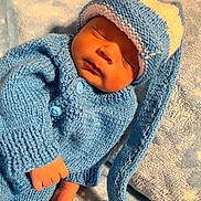Pablo is registered to the contest to win money with this photo: newborn, baby, sleeping, blue_clothing, knitted_hat, knitted_sweater, blanket, soft_texture, peaceful, infant, cute, sleep, hand, foot, cozy, warm, portrait, indoors, resting, child