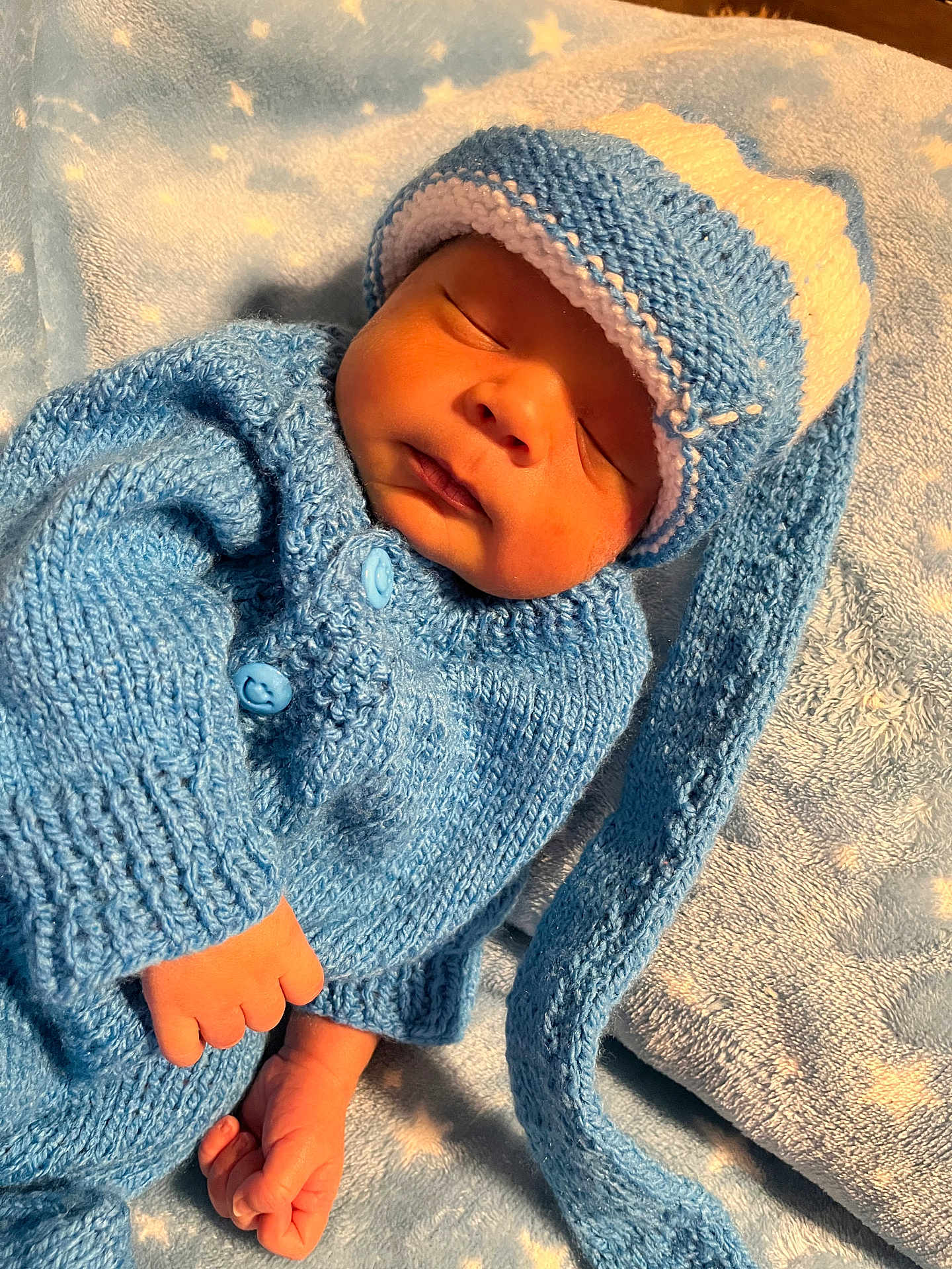 Pablo is registered to the contest to win money with this photo: newborn, baby, sleeping, blue_clothing, knitted_hat, knitted_sweater, blanket, soft_texture, peaceful, infant, cute, sleep, hand, foot, cozy, warm, portrait, indoors, resting, child
